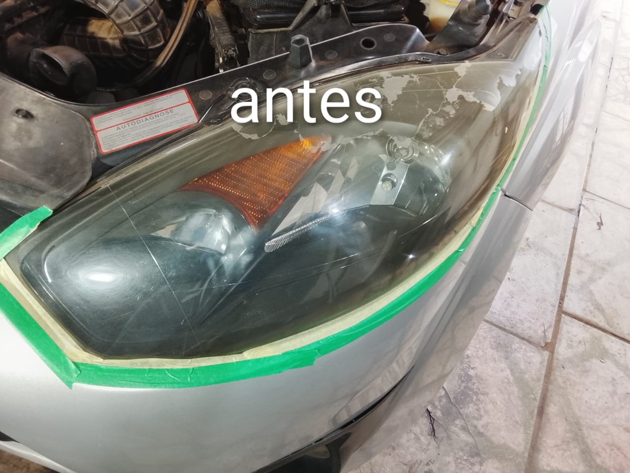 Farol de veículo antes da restauração, com opacidade e desgaste